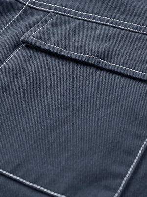 Close-up of dark blue fabric with white stitching