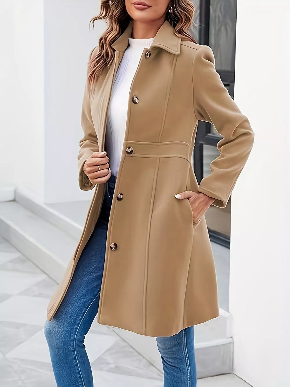 Woman wearing a beige coat with a white background