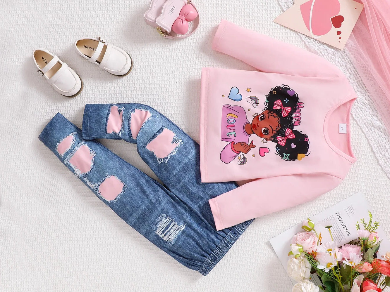 Children's outfit with pink sweater and blue jeans on a light background